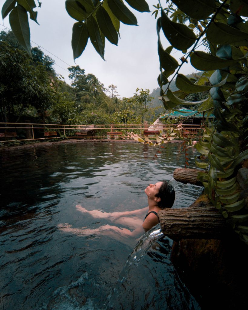 Person relaxing in a natural pool surrounded by lush greenery Dumaguete