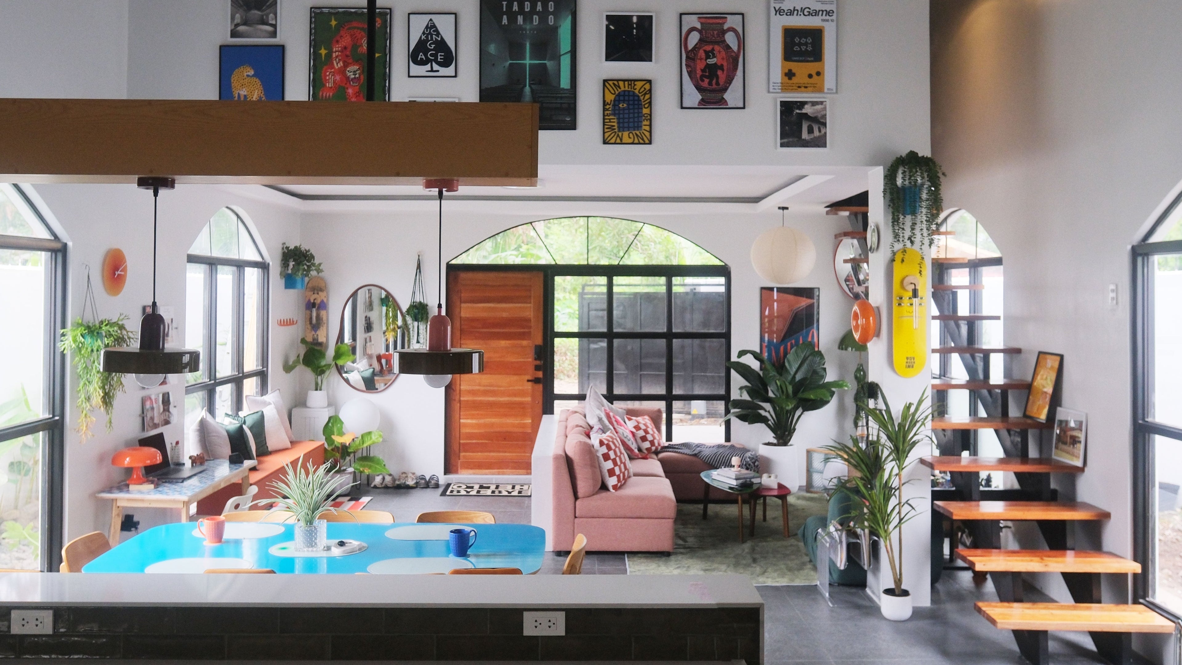 Modern living room with a large window, sofa, and decorative items.converted chapel airbnb dumaguete