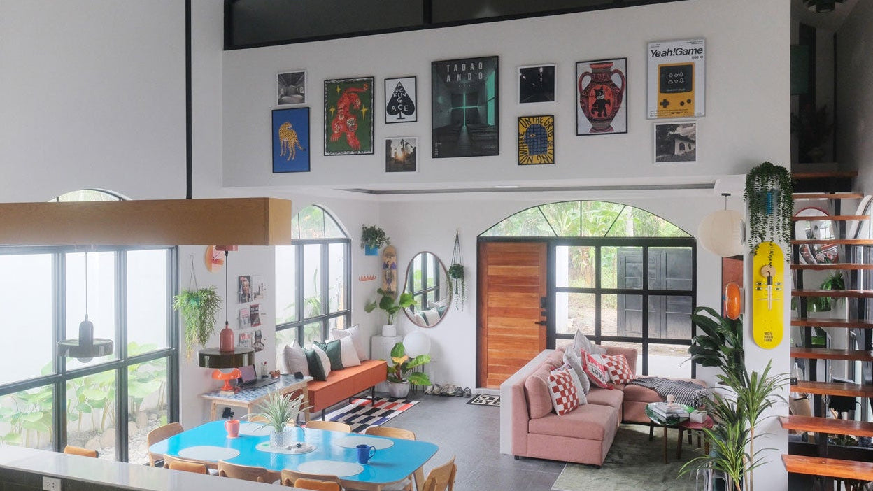 The RYZE converted chapel. Modern living room with a large TV mounted on the wall, bookshelf, and decorative items. 